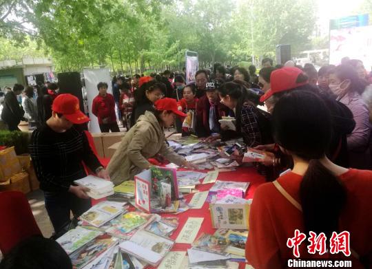 图为图书馆工作人员向市民发放图书。 刘鹏 摄 图为图书馆工作人员向市民发放图书。 刘鹏 摄