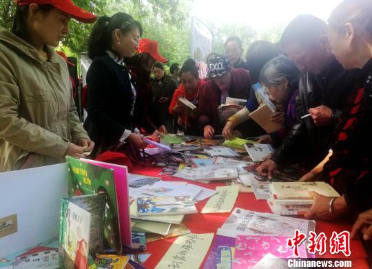 图为市民在现场免费选取图书。 刘鹏 摄 图为市民在现场免费选取图书。 刘鹏 摄