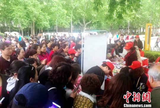 图为展览台被热情的市民围得水泄不通。 刘鹏 摄 图为展览台被热情的市民围得水泄不通。 刘鹏 摄