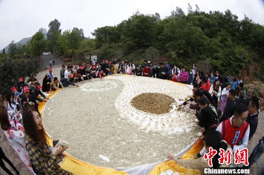 游人围观品尝“太极槐花宴”。 董飞 摄 游人围观品尝“太极槐花宴”。 董飞 摄