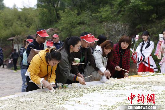 游人品尝“太极槐花宴”的蒸菜。 董飞 摄 游人品尝“太极槐花宴”的蒸菜。 董飞 摄